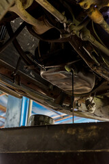 Drain the old oil from the engine through the drain plug. Changing the oil in a car engine. discharge of waste oil from motor car. Draining used diesel engine power from an oil pan into a container 