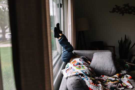 child sits upside down on couch