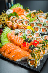 Sushi set (combo). Traditional Japanese cuisine, premium sushi decorated in elegant surroundings. Niguiri, Uramaki, Sushi Jow, Sashimi. Vertical photo.