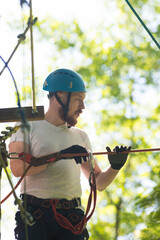 Rope adventure - man about to walk on the suspension rope bridge