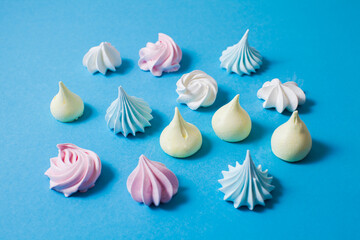 Top view colorful meringue cookies on blue background