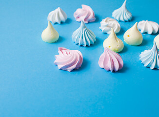 Delicious aerial meringue cookies on blue surface