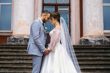 Fototapeta premium bride and groom cuddling, portrait of a wedding couple against the background of the building