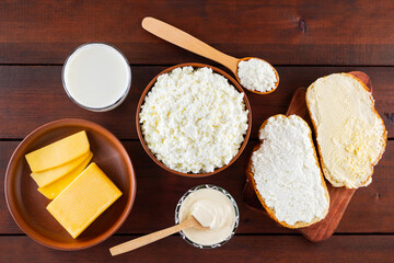 Dairy products. Milk, cottage cheese and sour cream in a rustic style. Bread with cream cheese on a wooden boards. Top view