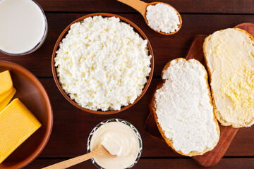 Dairy products. Milk, cottage cheese and sour cream in a rustic style. Bread with cream cheese on a wooden boards. Top view