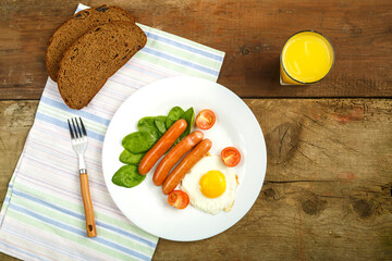 Scrambled eggs with sausages in the shape of a sun children's breakfast m glass of juice.