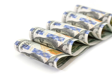 one hundred dollar bills fastened with clips on white.