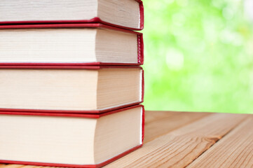 stack of books on the wood table in the nature with bokeh lights