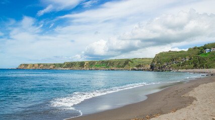 A view of a shore in Sao Miguel island, in The Azores archipelago. White clouds and blue sky in the background