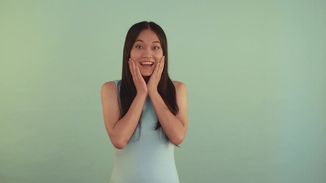 Portrait midle shoot. Very shosed Asian girl. Girl covers her mouth with hand 4K