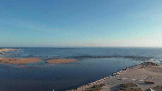 DRONE AERIAL FOOTAGE - The two sides of Restinga de Ofir. The Ronca de Esposende, a red and white colored beacon alerts on the pier, Portugal.
