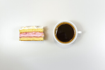 top view of piece of homemade cake and cup of natural black coffee on a white table