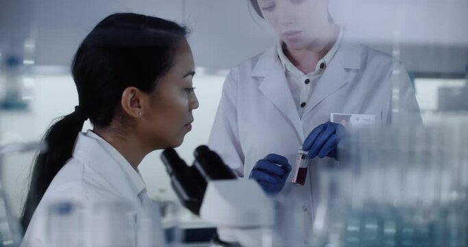Modern laboratory. Female scientist working with microscope. Biohazardous samples