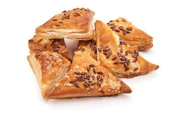 Puff pastry pies coated with flaxseeds, isolated on white background