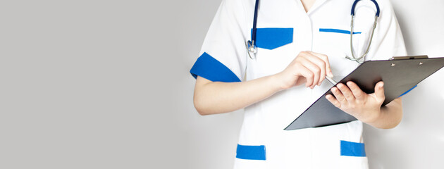 Hand of female doctor with pen writing on prescription blank