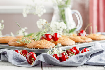 Homemade cherry muffins and fresh cherries on a light background. Delicious dessert