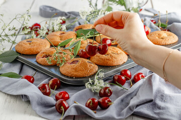 Freshly baked cherry muffins with fresh berries on a rustic wooden table