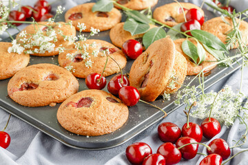 Homemade cherry muffins and fresh cherries on a light background. Delicious dessert