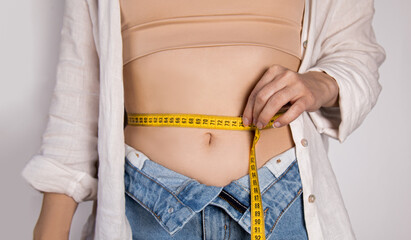 A woman takes measurements of her waist in pursuit of a slim body.
Body positive concept