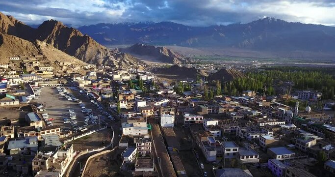 Aerial forward flying view over Leh city and its valley, surrounded by old houses and the mountain range of Himalaya, amazing travel destination in Ladakh, state of India