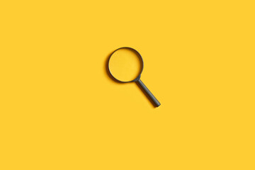 detective minimal concept. magnifier over bright yellow background. copy space.