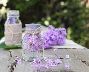 Obraz na płótnie Canvas Lilac flowers in a glass bottle. The preparation of infusions. Aromatherapy