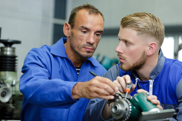 engineer training apprentice on cnc machine