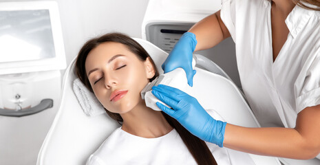 Elos epilation hair removal procedure on the face of a woman. Beautician doing laser rejuvenation in a beauty salon. Facial skin care. Hardware  ipl cosmetology - obrazy, fototapety, plakaty