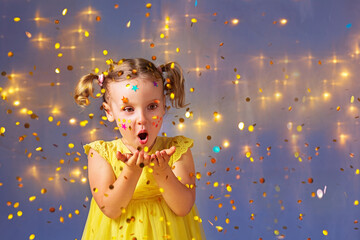 a girl blows confetti off her hands at a party