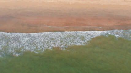 Aerial drone view of deserted Arambol beach on Goa with waves. India.