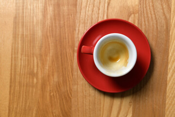 Red cup on a wooden table from which drank coffee