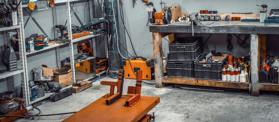 Garage, service area for disassembling, repairing motorcycles, car station. Inside workshop with large workbench, shelving, moto lift, tools kit for processing wrenches on wall. Banner for web site