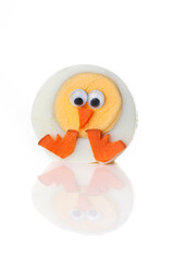 Food art creative concepts. Cute chick with big crest made of boiled egg, sesame seeds and carrots isolated over white background.