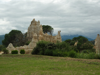 Sand chimneys created by erosion on a background cloudy sky