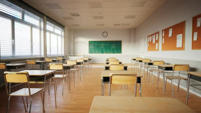 Empty classroom with chalkboard and rows of desks with chairs. Break at school.