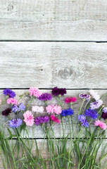 Colorful bouquet of summer garden flowers. Cornflowers on old shabby wooden table. Vintage floral background. Copy space
