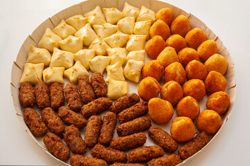 Brazilian traditional snacks, coxinha, quibe e esfiha. Finger food for celebrations. Deep fried and baked savory meal.