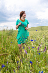 Happines girl on a wheat field  with cornflowers near road