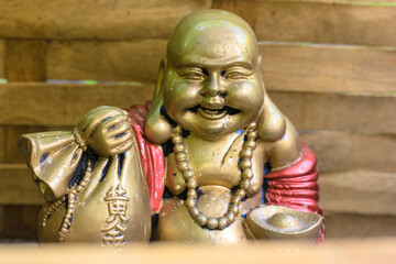 Fototapeta na wymiar Hotey, laughing Buddha is the god of communication, fun and well-being with a cloth bag of wealth and treasure in his hand.