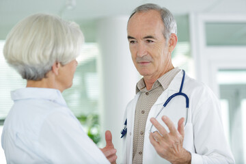 Fototapeta premium male senior doctor expressing health concerns with elderly man patient