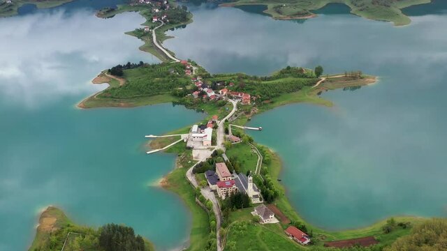 Fly over drone shot above the &Scaron;ćit Franciscan monastery at Rama Lake.