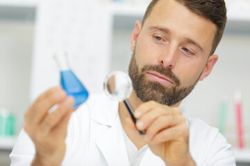 male lab worker with magnifying glass