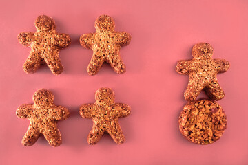 Fototapeta na wymiar cookie figures of men on pink background. Flat lay shot of freshly bakery gingerbread cookies man. Simple idea of community and capitalism