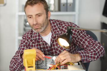 electrician using multimeter to test computer