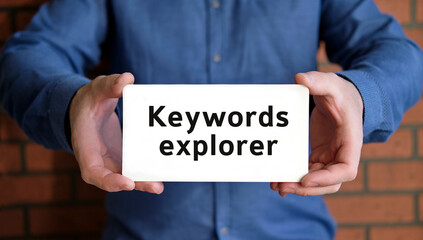 Keyword explorer for seo website - business concept in the hands of a young man in a blue shirt