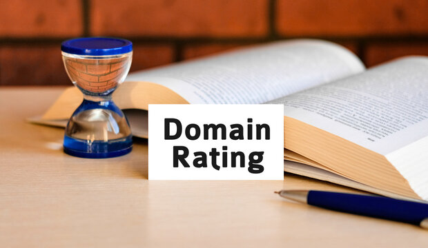 Domain rating business concept text on a white background with a hourglass and an open book