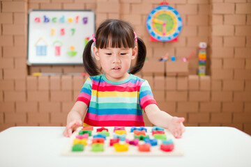 toddler girl learning letter blocks for homeschooling