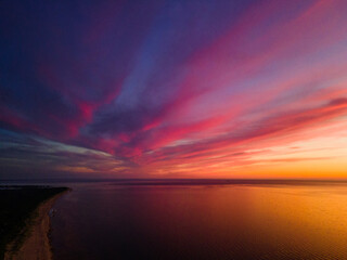 Fototapeta premium Epic vivid sunset or sunrise aerial view with sun setting down to the right. Amazing cloudscape