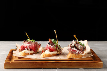 bruschetta with beef parmesan and microgreen on wood closeup. Traditional spanish tapas. set of three tapas