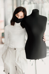 Woman Designer with a black mask and a mannequin